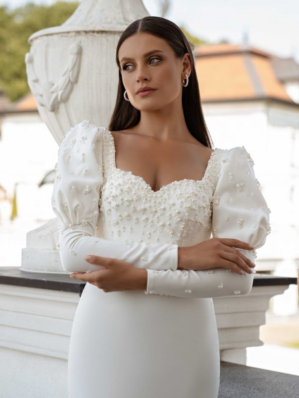 Σατέν ιβουάρ νυφικό με πέρλες και μακριά μανίκια.