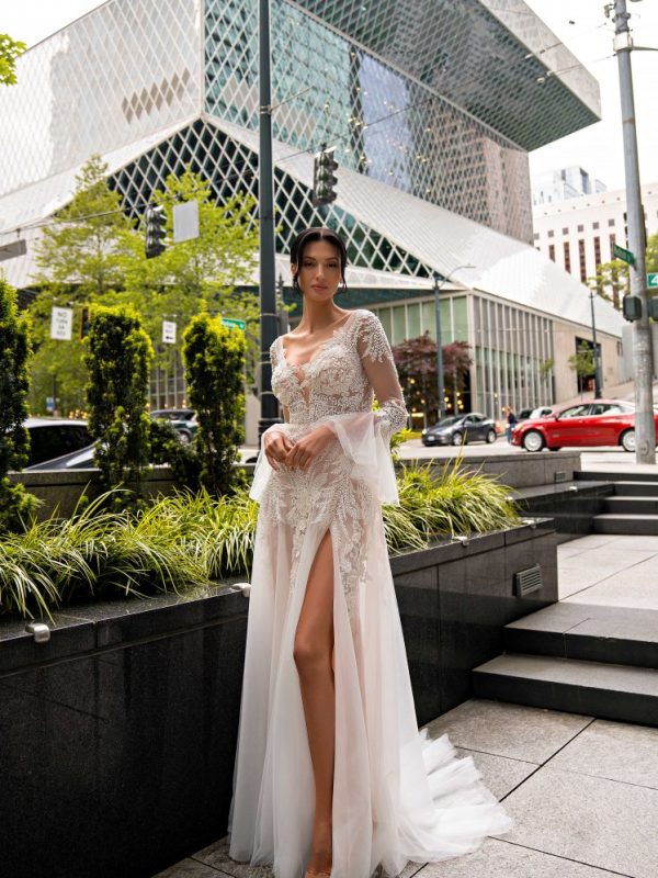 Boho νυφικό φόρεμα με μανίκια απο δαντέλα και άνοιγμα στη φούστα.