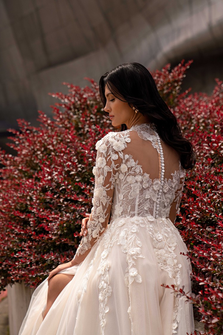 Γαλλική δαντέλα στο νυφικό με μανίκια και ιδιαίτερο γιακά.